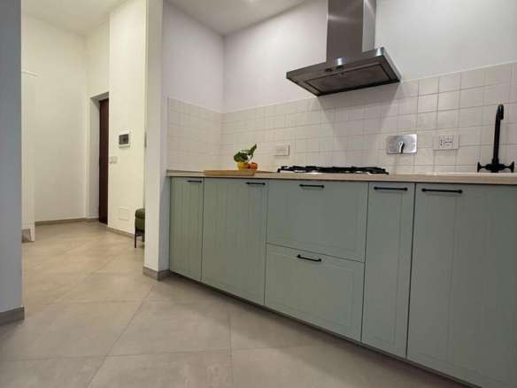 Уютная современная кухня в элитной недвижимости с минималистичным дизайном и встроенной техникой, идеально подходящая для комфортной жизни в роскошных апартаментах.