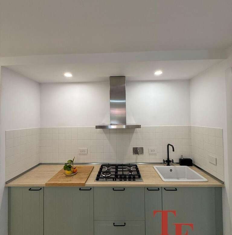 Современная кухня в элитной недвижимости, светлые фасады, встроенная техника, стильные светильники и функциональный дизайн, идеально подходящий для роскошной жизни.