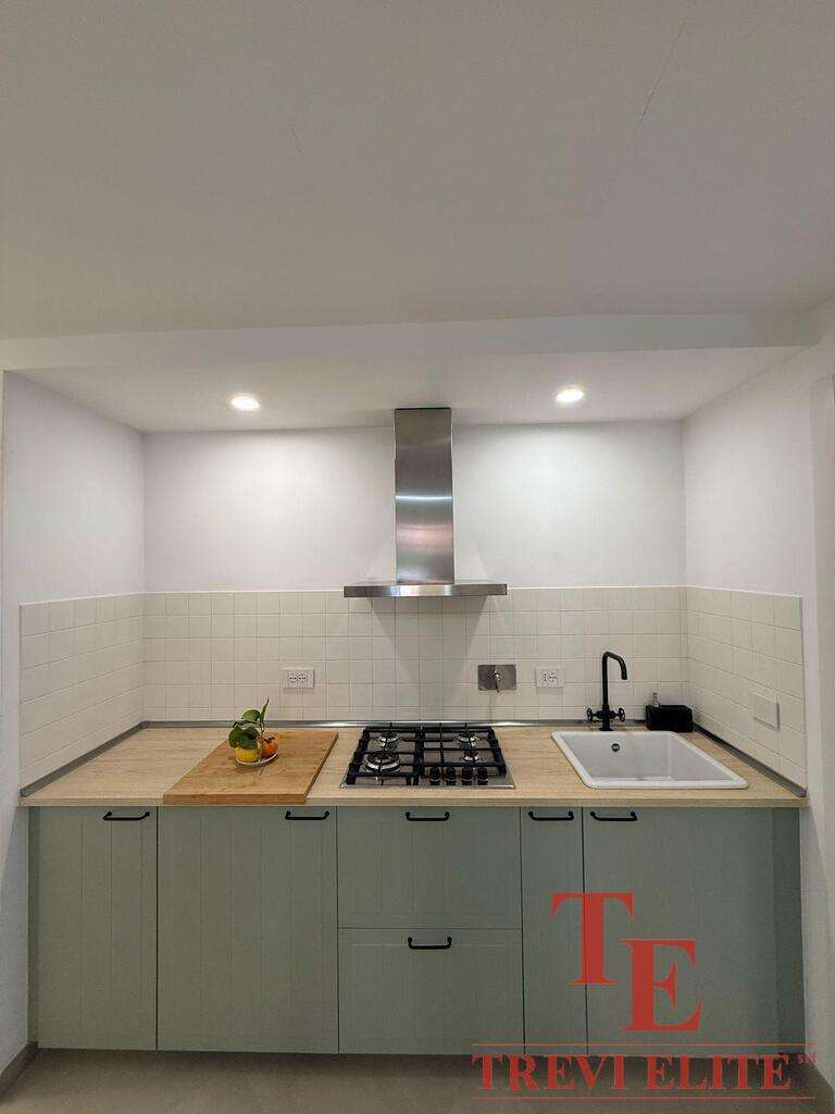 Современная кухня в элитной недвижимости, светлые фасады, встроенная техника, стильные светильники и функциональный дизайн, идеально подходящий для роскошной жизни.