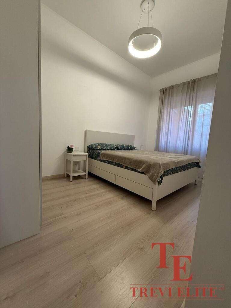 Современная спальня с мягким естественным освещением, минималистичный дизайн, белые стены, светлый деревянный пол, уютное окно с прозрачными шторами, стильная мебель для комфорта и уюта.