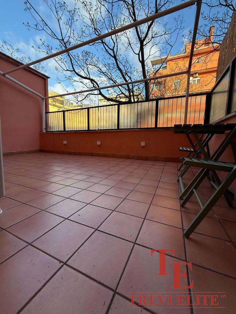 Просторная терраса с тёплой оттеночной плиткой, уютным ограждением и панорамным видом на город и деревья, идеально подходит для отдыха и развлечений под солнечным небом.