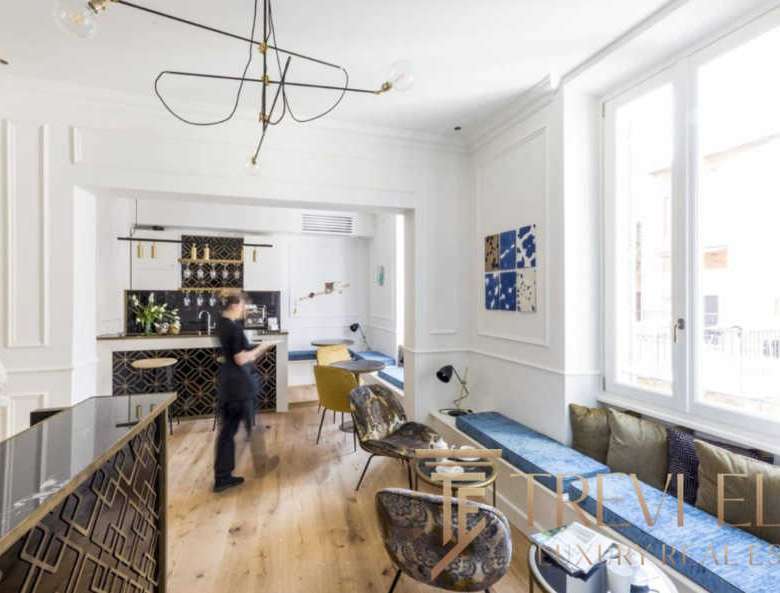 Элегантный интерьер уютного лофт-стиля с мягкой мебелью и яркими акцентами, просторные окна пропускают много естественного света, создавая приятную атмосферу роскоши и комфорта.