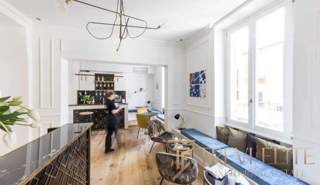 Элегантный интерьер уютного лофт-стиля с мягкой мебелью и яркими акцентами, просторные окна пропускают много естественного света, создавая приятную атмосферу роскоши и комфорта.