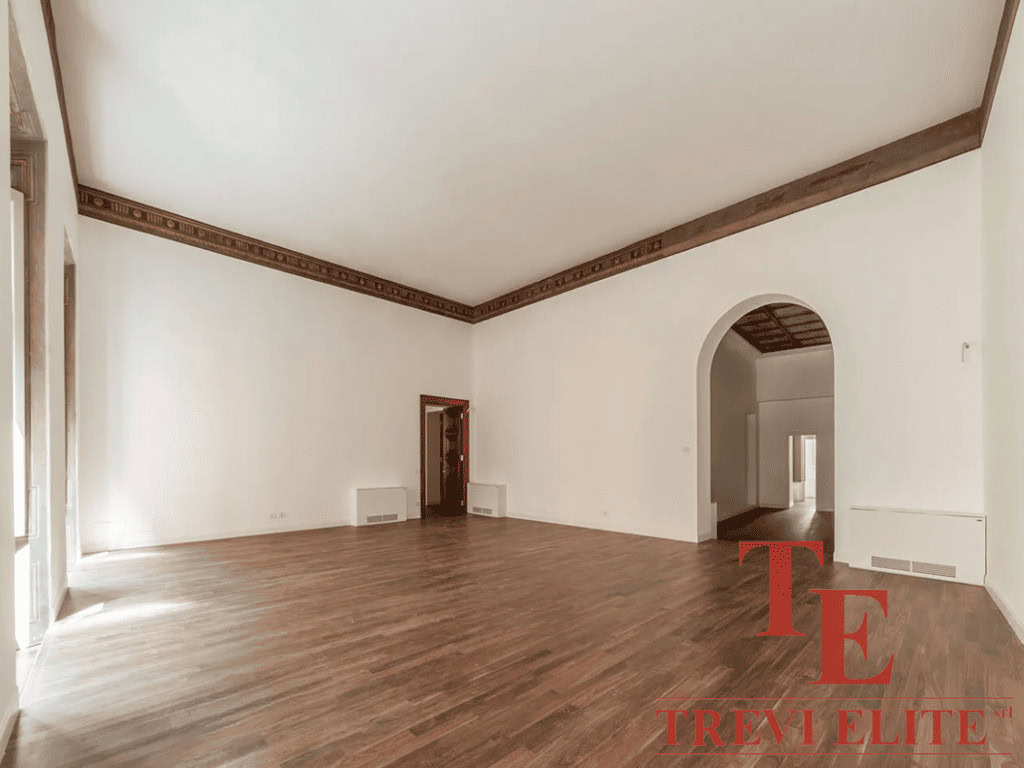 Современный просторный зал в элитной недвижимости с высоким потолком и деревянным полом, идеально подходящий для роскошной жизни и приемов.