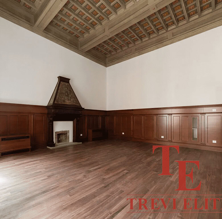 Роскошный интерьер с деревянными панелями, высоким потолком и камином в классическом стиле.