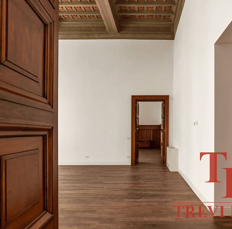 Роскошный интерьер с классическими деревянными дверями и высокими потолками, отражающий элитность и эксклюзивность высококлассных итальянских и мировых недвижимости от агентства Треви Элит.