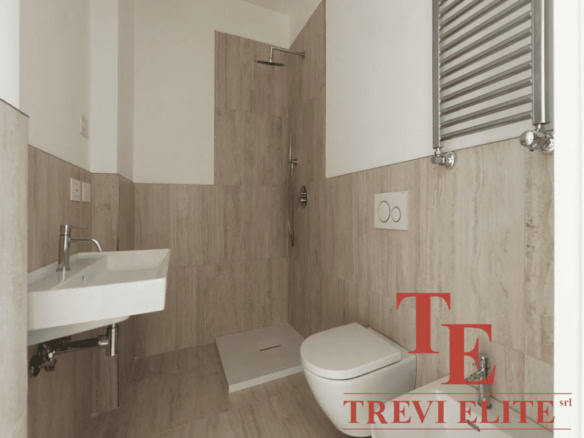 Современная ванная комната с душевой кабиной, унитазом и небольшим умывальником, отделанная светлым деревом, стильный дизайн, изысканная отделка.