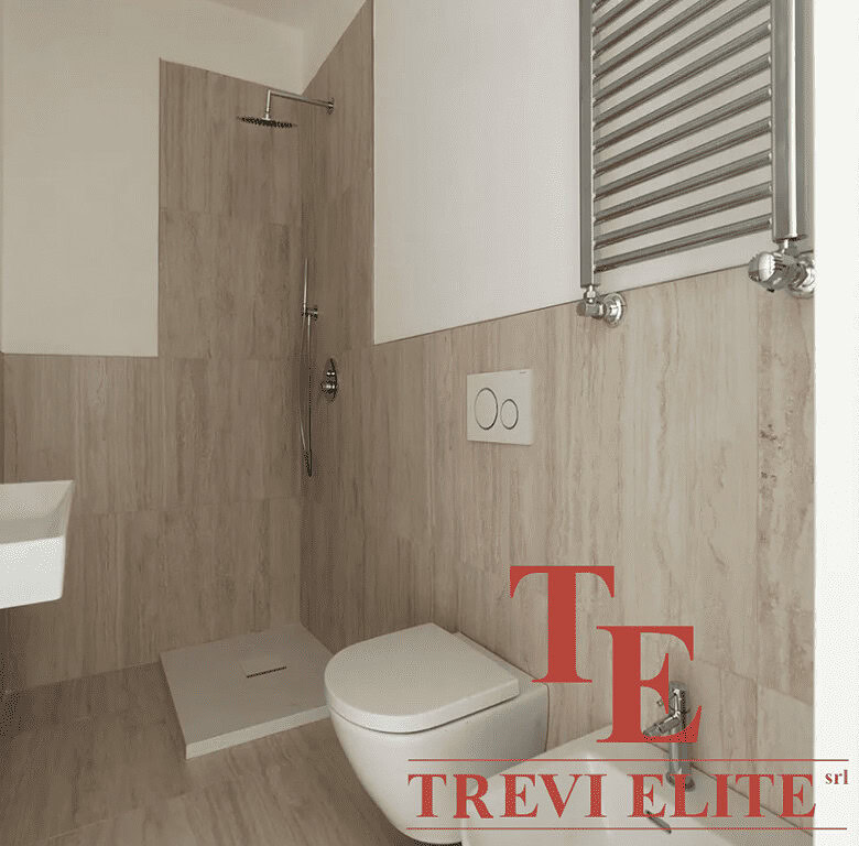 Современная ванная комната с душевой кабиной, унитазом и небольшим умывальником, отделанная светлым деревом, стильный дизайн, изысканная отделка.