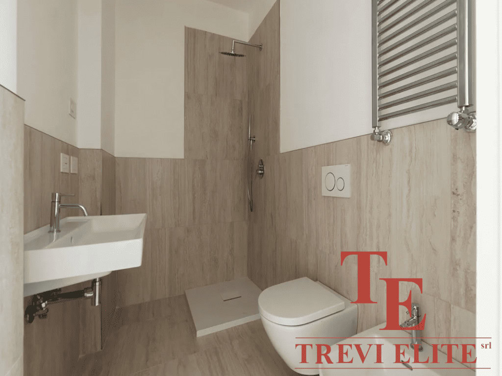 Современная ванная комната с душевой кабиной, унитазом и небольшим умывальником, отделанная светлым деревом, стильный дизайн, изысканная отделка.