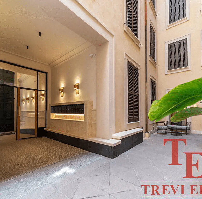 Современный дизайнерский вход в элитный жилой комплекс с уютной внутренней террасой и декоративной зеленью. Идеальное сочетание комфорта и элегантности в центре города.