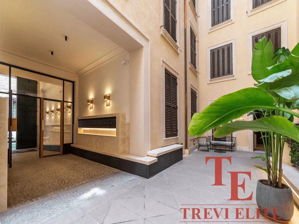 Современный дизайнерский вход в элитный жилой комплекс с уютной внутренней террасой и декоративной зеленью. Идеальное сочетание комфорта и элегантности в центре города.