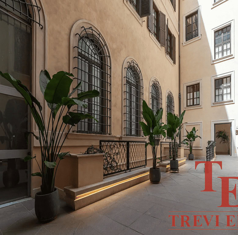 Уютный внутренний двор в классическом стиле с зелеными растениями и уютной атмосферой, идеально подходящий для высокого класса недвижимости и элитных апартаментов.