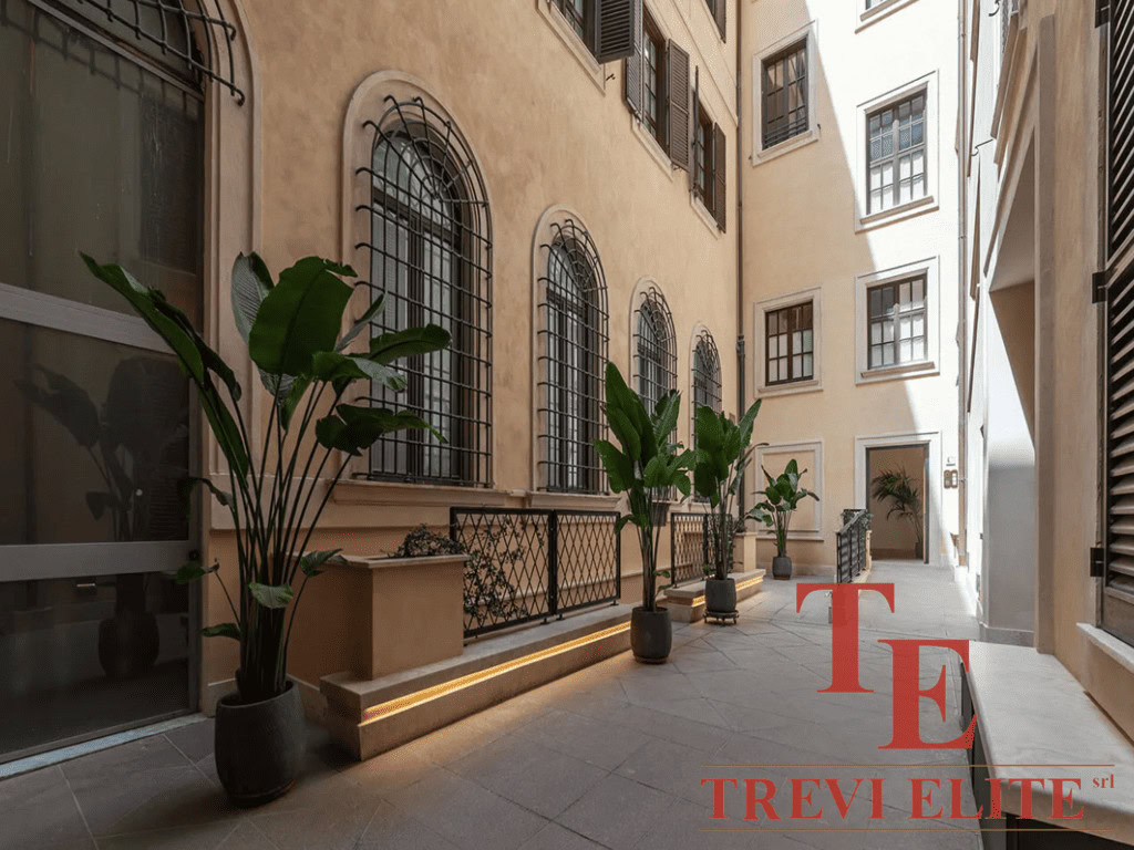 Уютный внутренний двор в классическом стиле с зелеными растениями и уютной атмосферой, идеально подходящий для высокого класса недвижимости и элитных апартаментов.