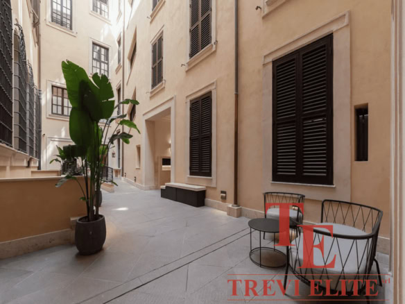 Стильный внутренний двор в европейском стиле с уютной мебелью и зеленью, идеально подходящий для эксклюзивных недвижимости высокого класса.