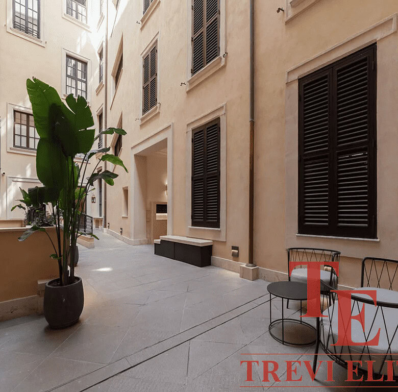 Стильный внутренний двор в европейском стиле с уютной мебелью и зеленью, идеально подходящий для эксклюзивных недвижимости высокого класса.