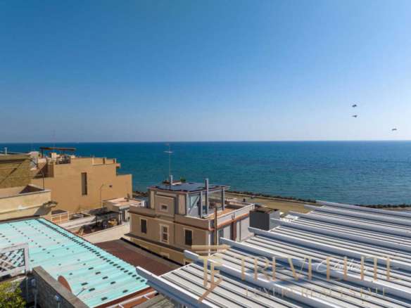 Высокий снимок роскошных жилых зданий у морского берега с красивым видом на море и голубым небом.