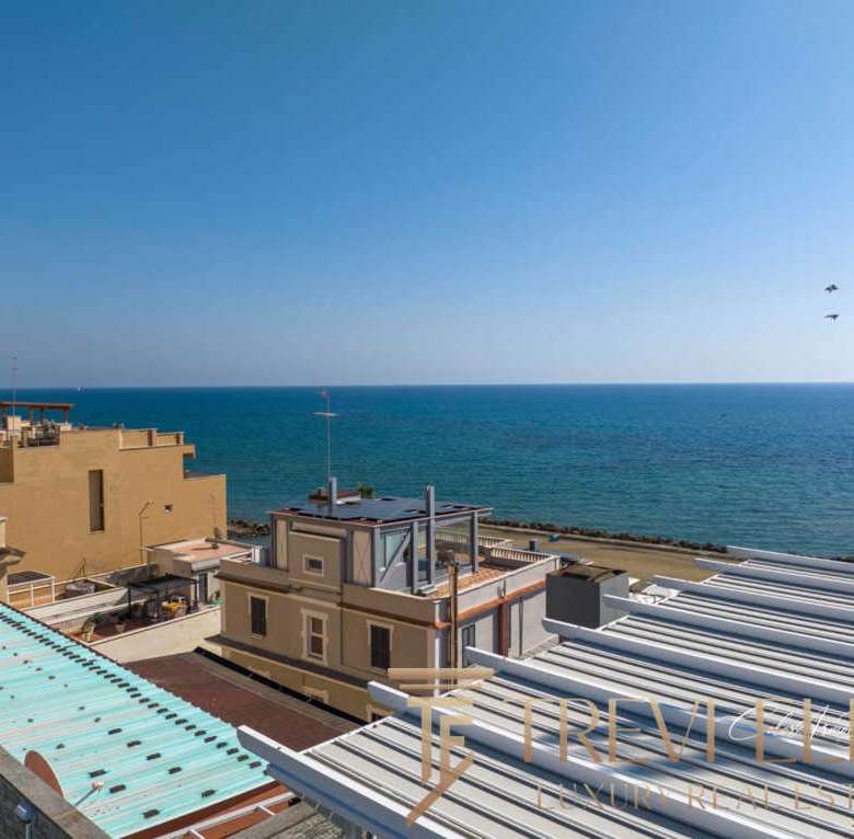 Высокий снимок роскошных жилых зданий у морского берега с красивым видом на море и голубым небом.