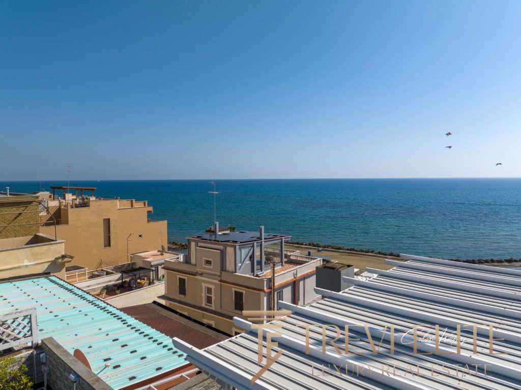 Высокий снимок роскошных жилых зданий у морского берега с красивым видом на море и голубым небом.