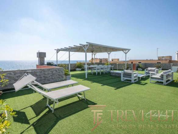 Роскошная терраса с видом на море, уютной зоной отдыха, шезлонгами и обеденной зоной под навесом, идеально подходит для роскошных вечеринок и релаксации на открытом воздухе.