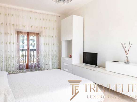 Элитная спальня с мягким светом, белой мебелью и современными деталями, привлекающая внимание к высокому уровню роскоши и комфорта в недвижимости Треви Элит.