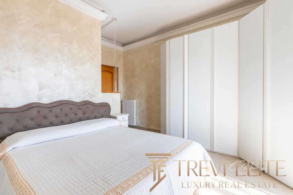 Роскошная спальня с мягкой изголовьем, просторным шкафом и светлыми стенами, подчеркивающими элитность недвижимости. Идеальное сочетание стиля и комфорта для высококлассной жизни.