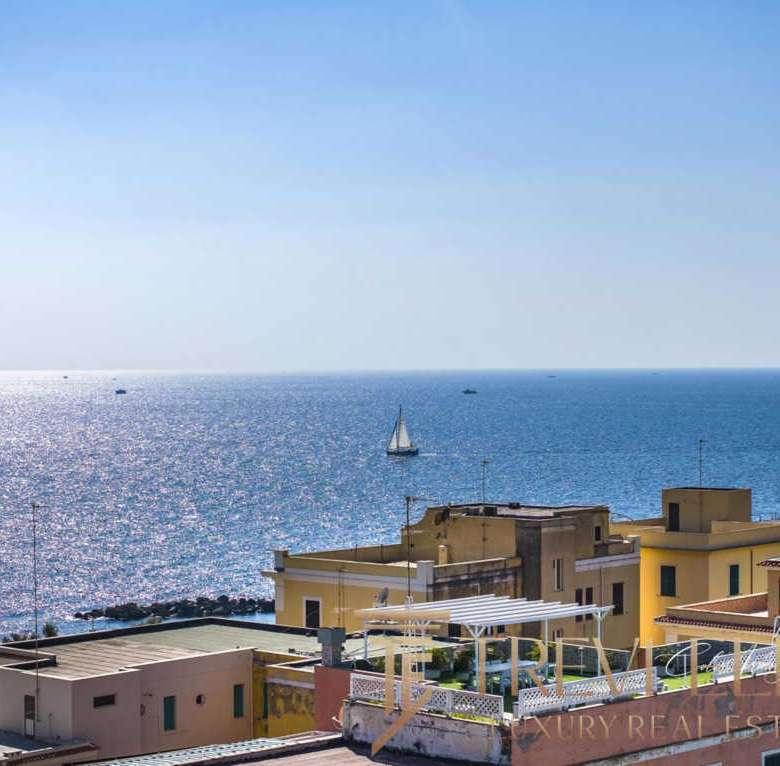 Вид на море и прибрежные дома на солнечном побережье Италии, роскошные апартаменты с террасами и солнечными зонами. Идеальное место для элитной недвижимости и отдыха на море.