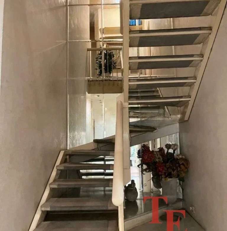 Элегантная лестница с деревянными ступеньками и балюстрадой в современном интерьере роскошного дома. Идеальное сочетание стиля и функциональности в элитной недвижимости.