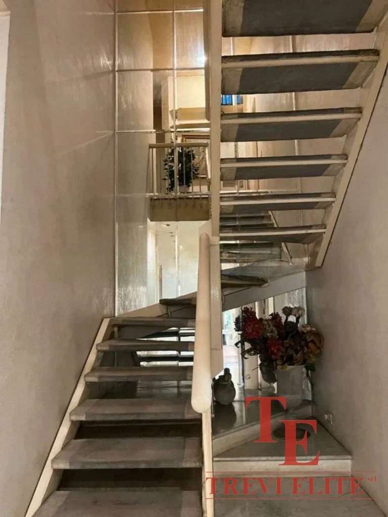 Элегантная лестница с деревянными ступеньками и балюстрадой в современном интерьере роскошного дома. Идеальное сочетание стиля и функциональности в элитной недвижимости.