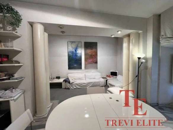 Элегантная гостиная в роскошной недвижимости от агентства Треви Элит, с уютным диваном, современной техникой и стильным интерьером, идеально подходит для комфортного отдыха и приема гостей.