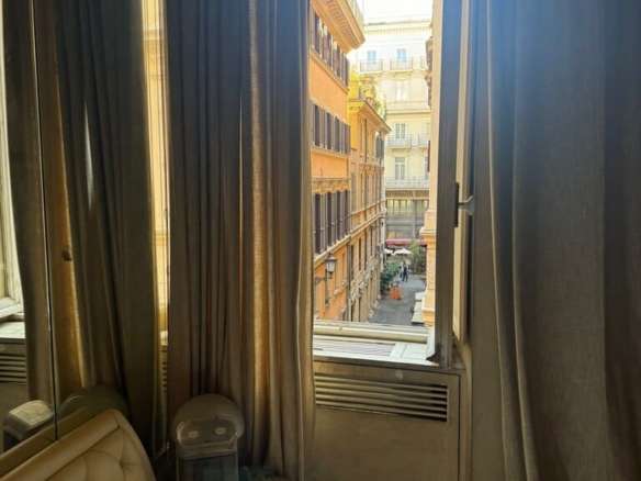 Современное уютное окно с видом на город в роскошной спальне, украшенное элегантными шторами, создающими атмосферу комфорта и роскоши.