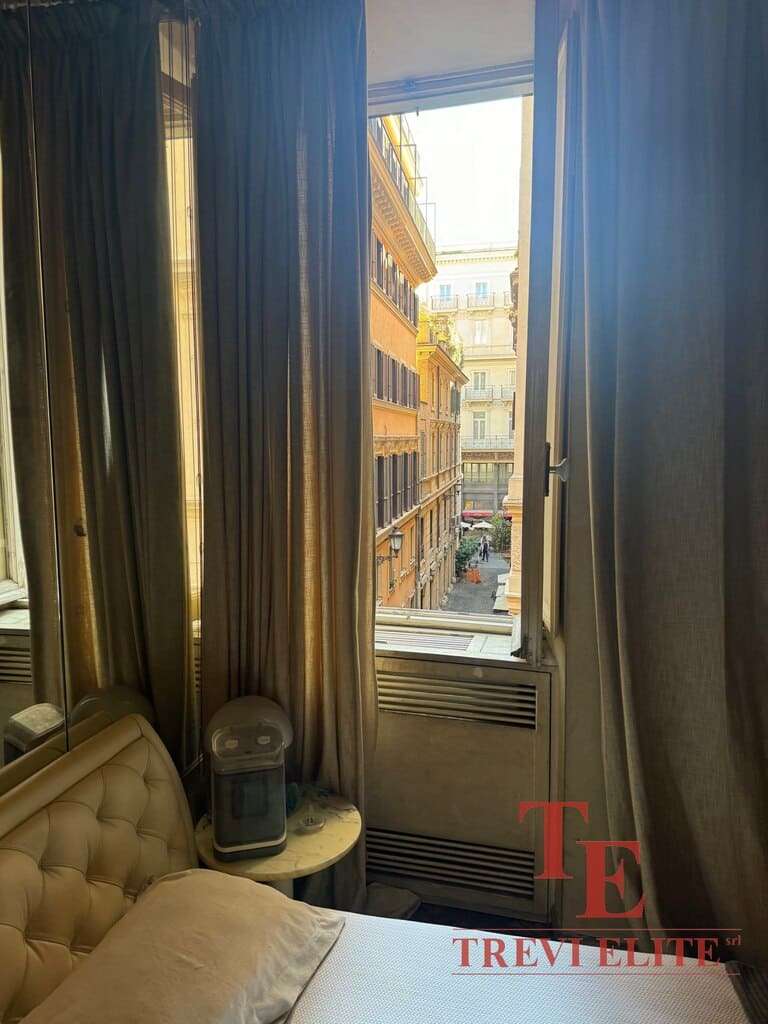 Современное уютное окно с видом на город в роскошной спальне, украшенное элегантными шторами, создающими атмосферу комфорта и роскоши.