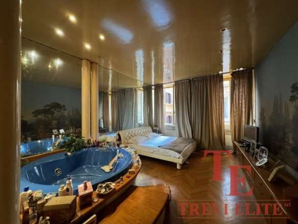 Роскошная спальня с просторной кроватью и панорамными окнами, украшенными тяжелыми шторами, в элитной недвижимости, элементы высокого класса и элегантности.