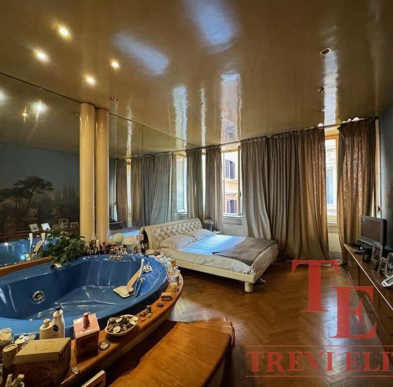 Роскошная спальня с просторной кроватью и панорамными окнами, украшенными тяжелыми шторами, в элитной недвижимости, элементы высокого класса и элегантности.