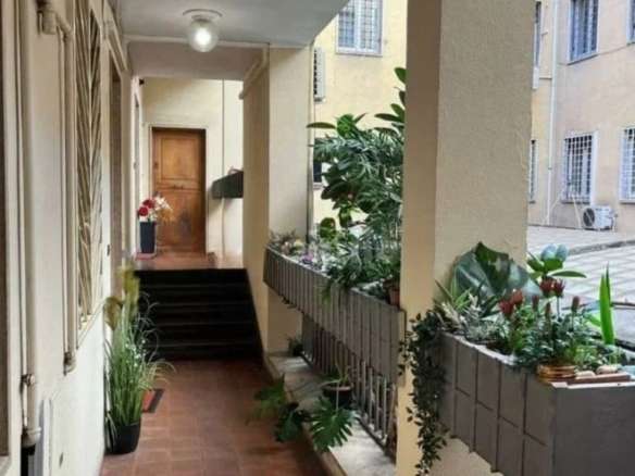 Элегантный коридор в жилом доме с зелеными декоративными растениями, просторными балконами и уютной атмосферой. Идеальное жилое пространство для ценителей комфорта и стиля.