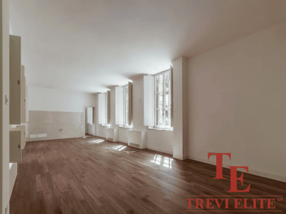 Просторная светлая комната с большими окнами, естественное освещение, теплый деревянный пол, современная отделка, идеально подходит для роскошных апартаментов.