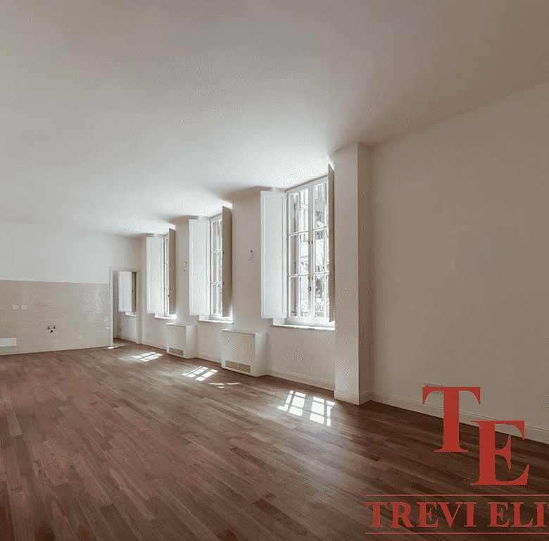 Просторная светлая комната с большими окнами, естественное освещение, теплый деревянный пол, современная отделка, идеально подходит для роскошных апартаментов.