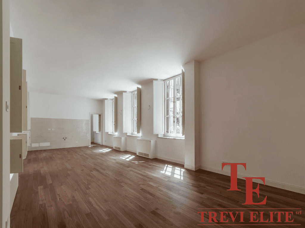 Просторная светлая комната с большими окнами, естественное освещение, теплый деревянный пол, современная отделка, идеально подходит для роскошных апартаментов.