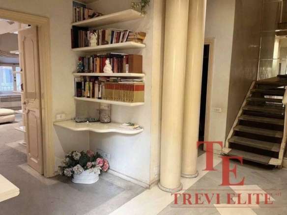 Высококачественная мебель и дизайнерское оформление внутри элитного жилого комплекса в Италии. Элегантное оформление интерьера с книжными полками, колоннами и цветами.