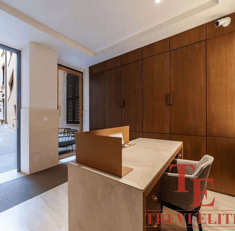 Современное интеррьерное пространство с деревянными панелями, просторным рабочим столом и выходом на уютный балкон с растениями. Идеальный дизайн для элитной недвижимости в Италии и мире.