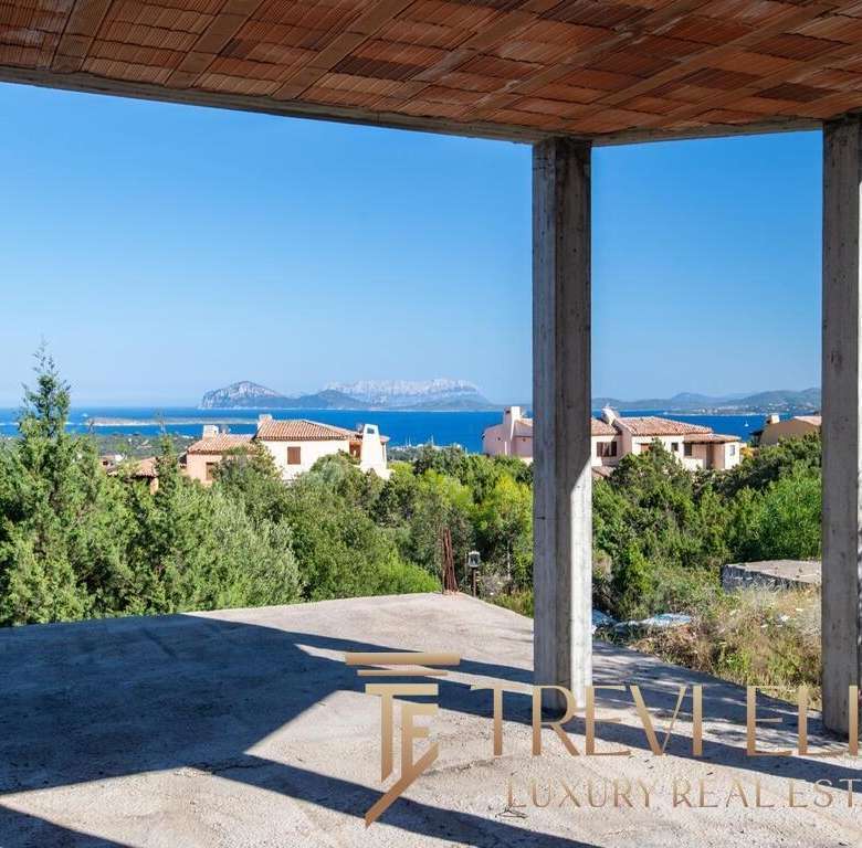 Вид из будущей роскошной виллы на берегу с открытой террасы и видом на море, горы и современные дома. Идеальное место для элитной недвижимости с панорамным обзором.