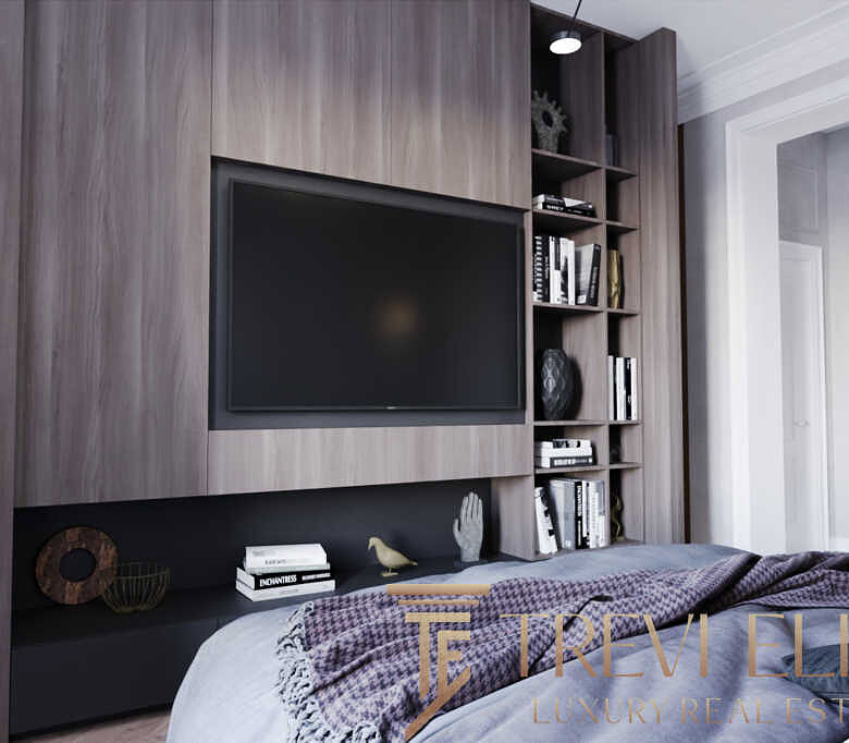 Современная гостиная с встроенным телевизором, элегантной shelving-системой и стильным декором, создающая уютную атмосферу для семейного отдыха и развлечений.