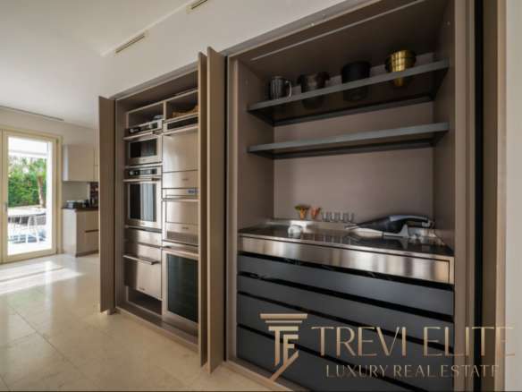 Высокотехнологичная встроенная кухня с стильной мебелью и бытовой техникой, современный дизайн интерьера в элитной недвижимости Треви Элит.