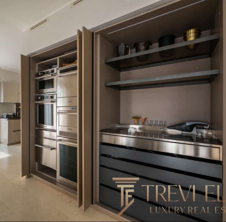 Высокотехнологичная встроенная кухня с стильной мебелью и бытовой техникой, современный дизайн интерьера в элитной недвижимости Треви Элит.
