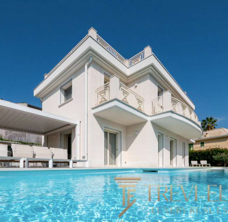 Элитная вилла с бассейном на берегу моря, современный дизайн, просторные окна, патио и ухоженный сад, расположенная в престижном районе Италии. Идеальное жилье для роскошной жизни и инвестиций.