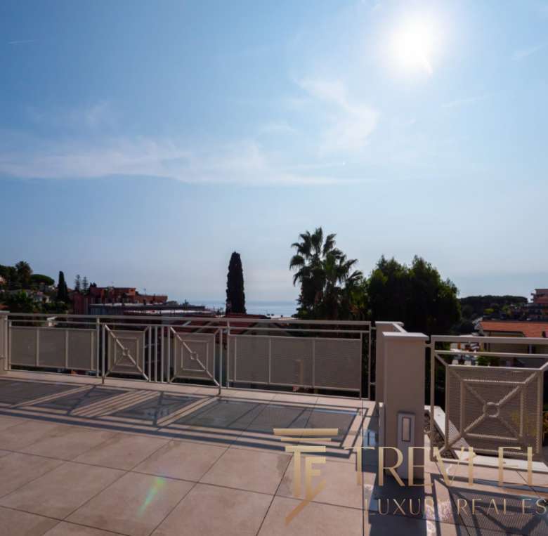 Уютный балкон с видом на море и город, окружённый зеленью, идеальное место для отдыха и наслаждения природой в элитных виллах Италии.