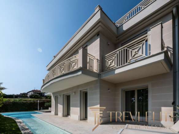 Элитный современный дом с бассейном, роскошным фасадом и уютными балконами, идеальный для ценителей высокого стиля и комфорта в престижном районе.