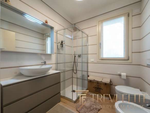 Высококачественный дизайн ванной комнаты в роскошной недвижимости, современные материалы и функциональность, светлые стены, большая окно, стильное оборудование и уютная атмосфера.