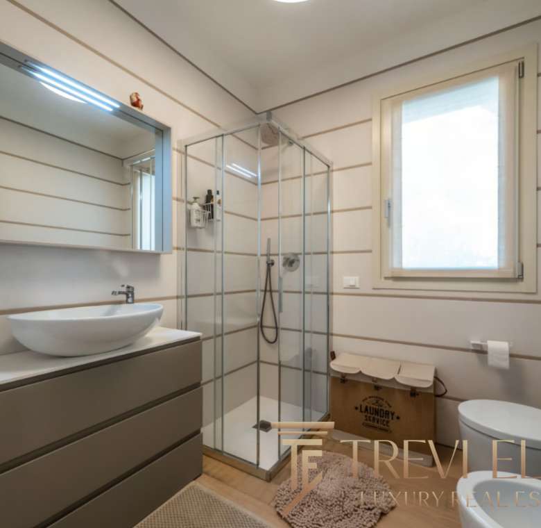 Высококачественный дизайн ванной комнаты в роскошной недвижимости, современные материалы и функциональность, светлые стены, большая окно, стильное оборудование и уютная атмосфера.