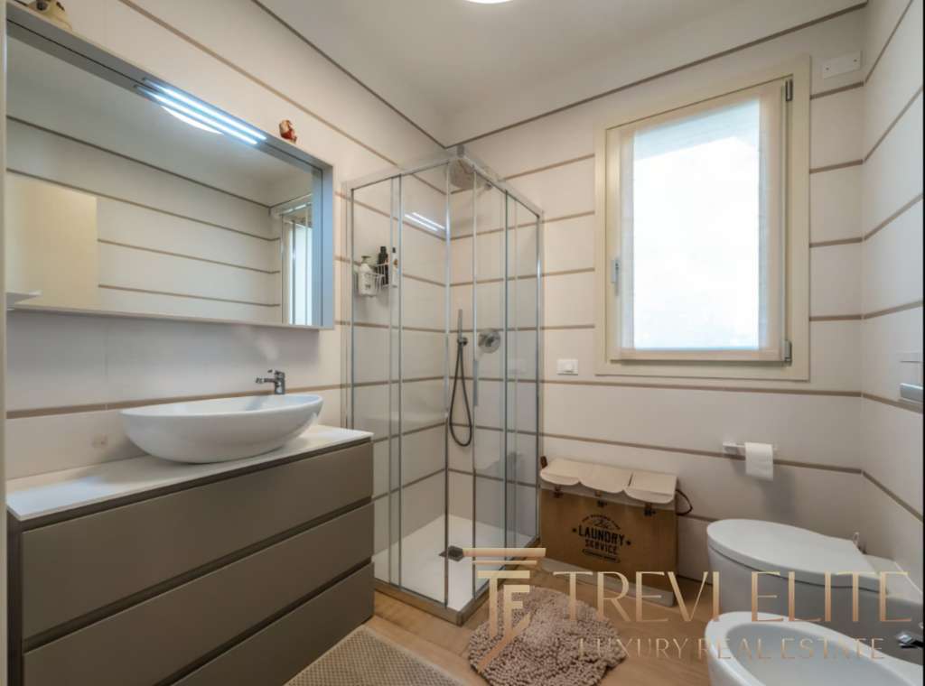 Высококачественный дизайн ванной комнаты в роскошной недвижимости, современные материалы и функциональность, светлые стены, большая окно, стильное оборудование и уютная атмосфера.