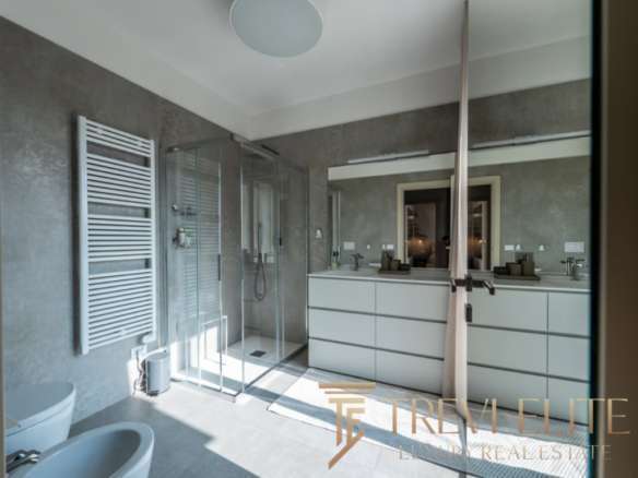 Современная ванная комната в элитном жилье с просторной душевой кабиной, стильной отделкой и зеркальными фасадами. Идеальный дизайн для комфортного и роскошного проживания.